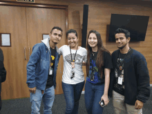 a woman wearing a game of thrones shirt poses for a photo with three other people