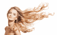 a woman with long blonde hair blowing in the wind against a white background