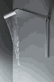 a shower head with water coming out of it is on a wall .