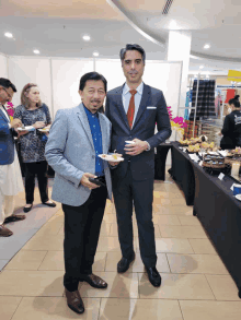 a man in a suit and tie stands next to another man