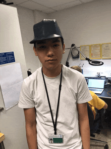 a young man wearing a hat and a lanyard with a name tag that says ' j. ' on it