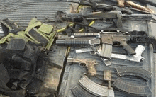 a bunch of guns are sitting on top of each other on a truck bed .