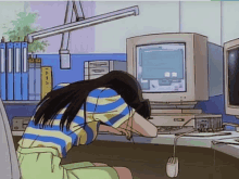 a girl is sitting at a desk with her head on a computer monitor .