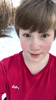 a young boy wearing a red shirt with the word ain on the back