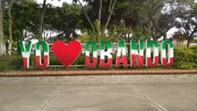 a red , white and green sign with a heart in the middle of it .