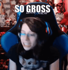 a woman is sitting in a blue gaming chair with the words `` so gross '' written on the back .