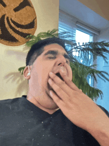 a man yawning in front of a basket on the wall