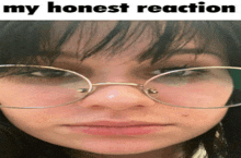 a girl wearing glasses with the words my honest reaction written above her