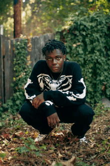 a young man wearing a black and white sweater with a snake on it