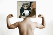 a boy is flexing his muscles in front of a picture of a cat in a tuxedo