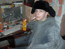 a man sitting in front of a computer with a carton of orange juice