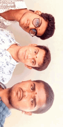 three young men are posing for a picture and one has a red spot on his forehead