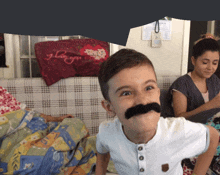 a boy with a fake mustache looks at the camera