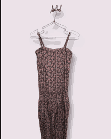 a floral dress is hanging on a hanger on a hook