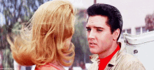 elvis presley and a woman are looking at each other in a movie scene .