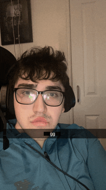 a young man wearing glasses and headphones is taking a selfie with a caption that says 99