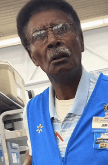 a man wearing glasses and a walmart vest with a name tag that says proud veteran