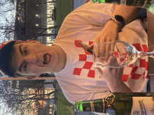 a man sitting at a table holding a glass and a bottle of opramen