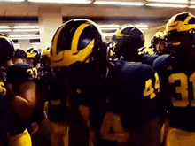 a group of football players are huddled together in a huddle .