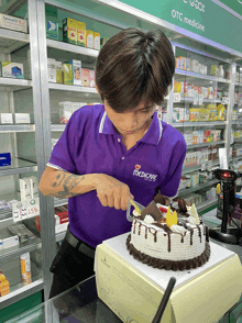 a man wearing a purple shirt that says medicare on it is cutting a cake