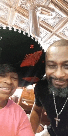 a man wearing a sombrero and a woman wearing a pink shirt pose for a photo