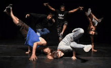 a group of young men are doing handstands on a stage .