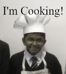 a boy wearing a chef 's hat with the words i 'm cooking behind him