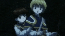 a couple of anime characters standing next to each other in a dark room .