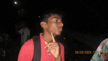 a young man in a red shirt has the date 26/03/2024 on his photo