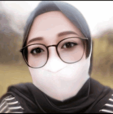 a woman wearing glasses and a hijab making a funny face