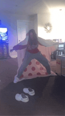 a girl is standing on a large pizza slice