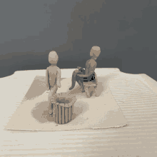 a clay sculpture of a man sitting on a bench next to another clay sculpture