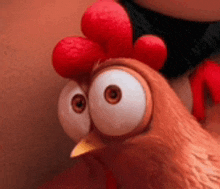 a close up of a cartoon chicken with big eyes and a red comb .