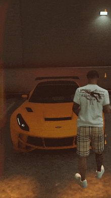 a man wearing a shirt that says scott is standing in front of a yellow sports car