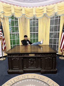 a man sits at a desk in the president 's oval office