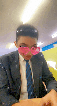 a man wearing a suit and tie has pink heart shaped glasses on his face