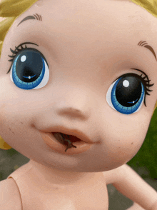 a close up of a baby doll with a snail in her mouth