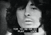 a black and white photo of a man 's face with a tcr play lock displayed