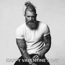 a man with a beard and tattoos is wearing a white t-shirt with the words happy valentine 's day on it