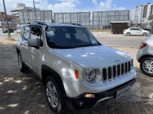 a white jeep with license plate dev324 is parked on the side of the road