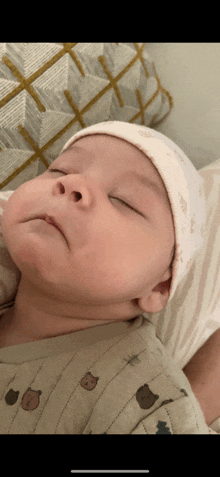 a baby wearing a white hat is sleeping