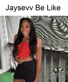 a woman in a red top and black shorts is standing in front of a wall with the words jaysevv be like