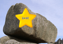 a large rock with a yellow star on top that says babe