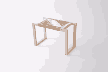 a wooden stool with a woven seat sits on a white background