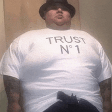 a man wearing a white shirt that says trust n 1