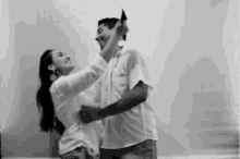 a man and woman are dancing together in a black and white photo .