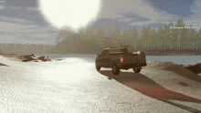 a ford truck is driving down a sandy road near a body of water