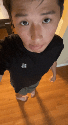 a young man taking a selfie with a black t-shirt that says ' help ' on the front