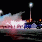 a group of people are standing in a parking lot in front of a blue bus that says peace on it