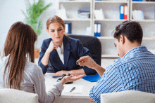 a man and woman are sitting at a desk with a woman holding a key